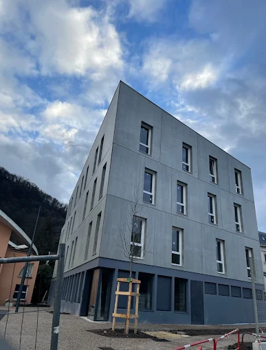 Immeuble moderne peint à Chambéry, façade grise soignée réalisée par Deniz Peinture, expert en peinture bâtiment.